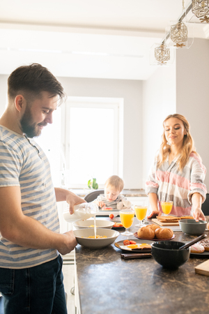 Happy Family Enjoying Breakfast with Babyの写真素材