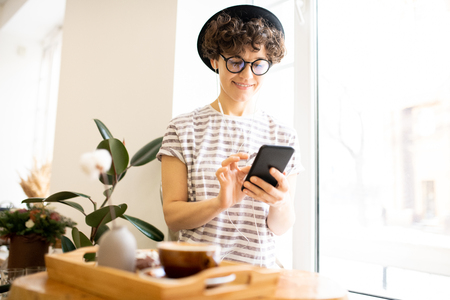 Modern woman using smartphone in cafeの写真素材