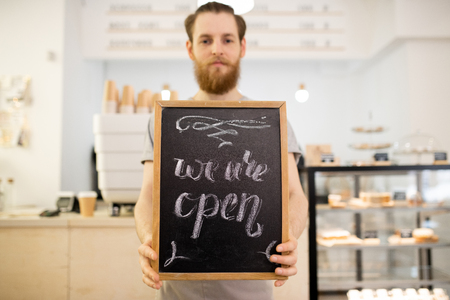Barista holding tablet with We are open inscriptionの写真素材