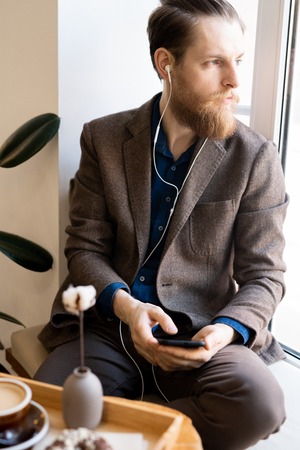 Introspective hipster man listening to music in earphonesの写真素材