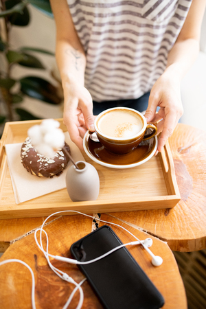 Drinking cappuccino in coffee shopの写真素材