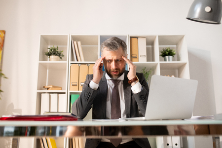 Depressed businessman confused with paperworkの写真素材