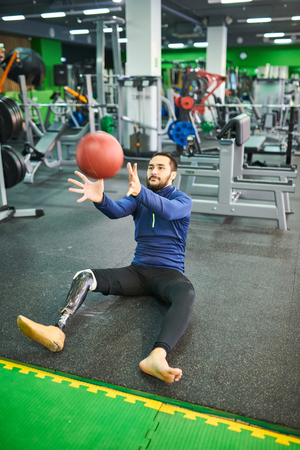 Bearded man with prosthetic leg catching ballの写真素材