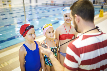 Group of girls listening to swim trainerの写真素材