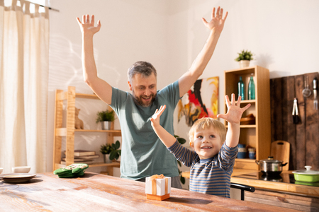 Excited father and son enjoying gift packagingの写真素材