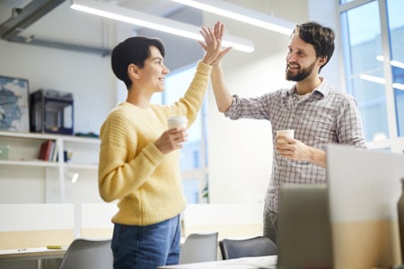 Excited colleagues giving high five