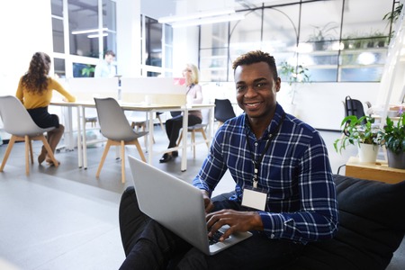 Cheerful black manager in comfortable officeの写真素材
