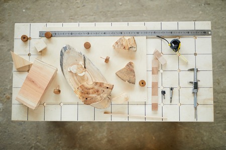 Carpenters desk with tools and wooden piecesの写真素材
