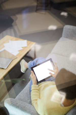 Young woman using tablet in lobbyの写真素材