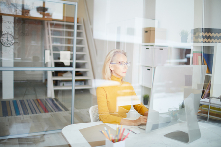 Mature Businesswoman Working behind Glassの写真素材