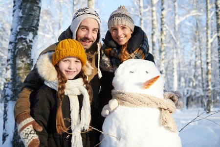 Family Posing with Snowmanの写真素材