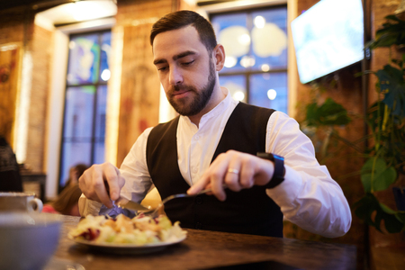 Handsome Businessman Eating in Restaurantの写真素材
