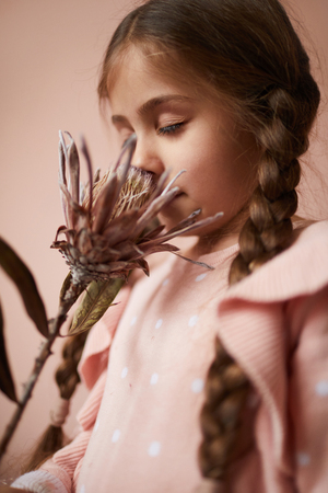Cute Little Girl Smelling Flowerの写真素材