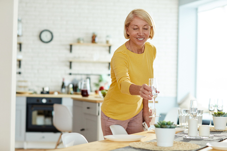 Smiling woman putting flute on tableの写真素材