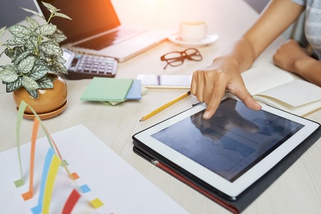 Close-up image of businesswoman zooming out image of diagram on tablt computerの写真素材