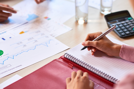 Hands of business people discussing charts and graphs at meetingの写真素材