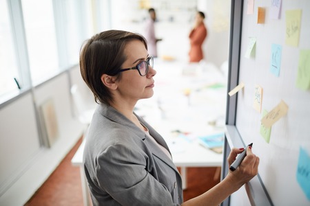 Businesswoman Writing on Whiteboardの写真素材