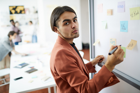 Middle-Eastern Businessman Writing on Whiteboardの写真素材