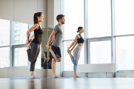 Stretching hips at yoga classの写真素材