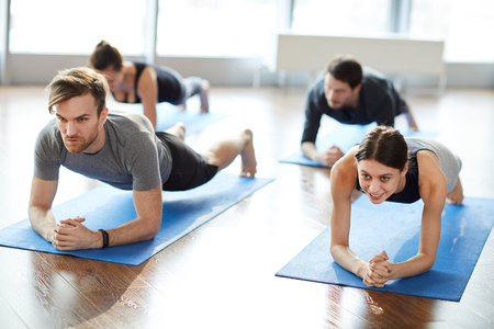 Motivated young people doing elbow plankの写真素材