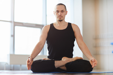 Muscled young man meditating aloneの写真素材