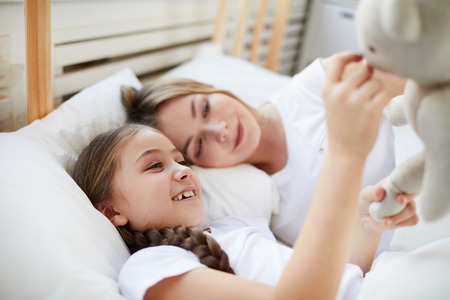 Mother and Daughter Lying in Bedの写真素材