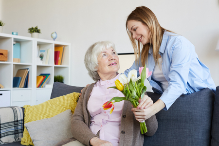 Woman Giving Flowers to Motherの写真素材