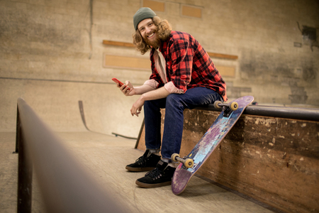 Smiling Skater Using Smartphoneの写真素材