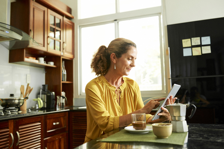 Mature woman working on digital tabletの写真素材