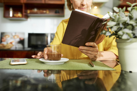 Woman enjoying coffee and good bookの写真素材