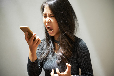 Woman shouting at smartphoneの写真素材