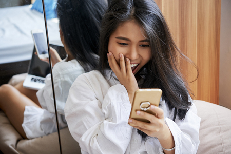 Young woman reading text messageの写真素材