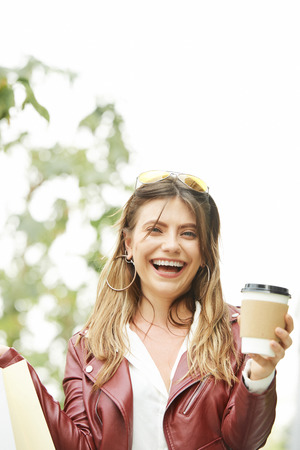 Pretty woman with coffee standing outdoorsの写真素材