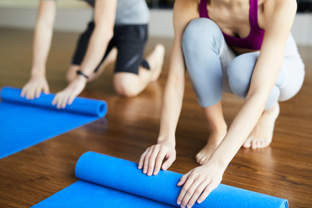Rolling yoga mats after classの写真素材
