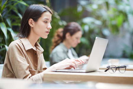 Thoughtful lady working with laptopの写真素材