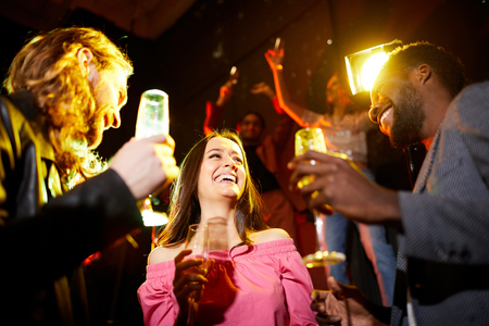 Excited lady between two guys at partyの写真素材