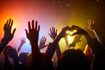 Fans waving hands at concertの写真素材
