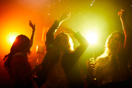 Positive youth dancing in smoky dark dance hallの写真素材