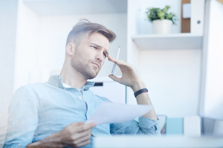 Pensive Businessman in Officeの写真素材