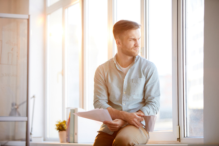 Pensive Businessman Sitting by Windowの写真素材