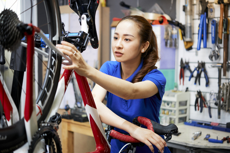 Woman in biking repair shopの写真素材