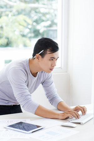 Busy Vietnamese IT engineer coding informationの写真素材