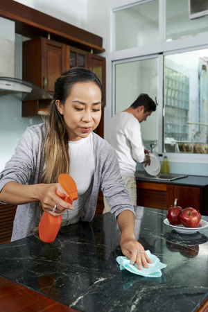 Woman cleaning kitchen islandの写真素材