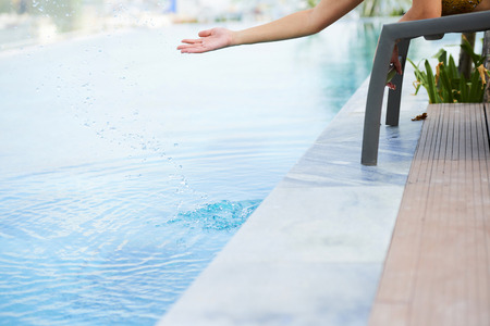 Woman touching water in poolの写真素材
