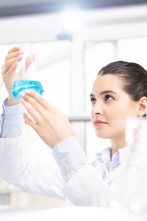 Checking chemical liquid in flaskの写真素材