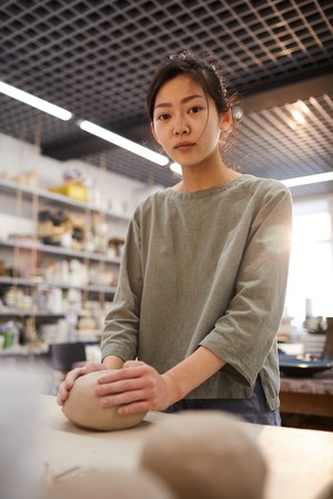 Asian girl working in pottery workshopの写真素材