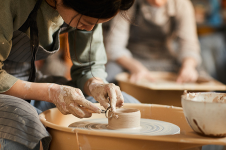 Shaping wet clay on pottery wheelの写真素材