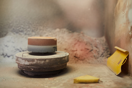 Pottery wheel with stand for painting crockery and sponge in dirty space with colorful walls, copy spaceの写真素材