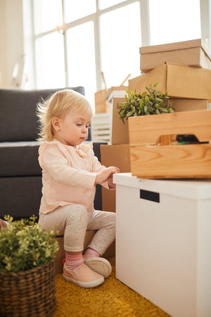 Curious girl opening moving boxの写真素材