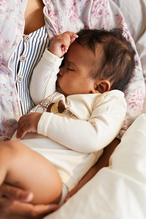 Holding sleepy baby in armsの写真素材